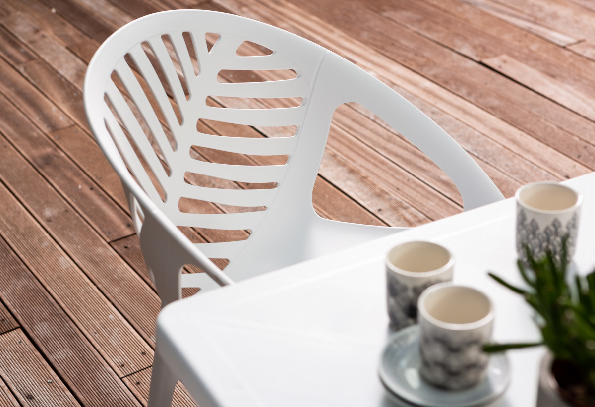 Στην εικόνα απεικονίζεται η  καρέκλα και ένα τραπέζι σε έναν κήπο.